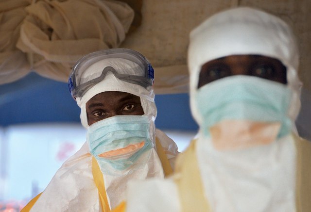 DON'T TOUCH Health workers in protective gear prepare to see patients at the Ebola-treatment center in the courtyard of Donka hospital, in Conakry, Guinea.