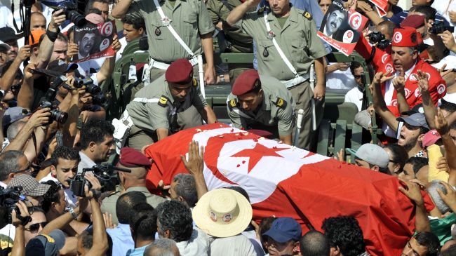 Tunisian soldiers salute as they load the coffin of assassinated opposition leader Mohamed Brahmi during his funeral procession in Tunis on July 27.