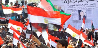 A crowd of people holding flags and banners.
