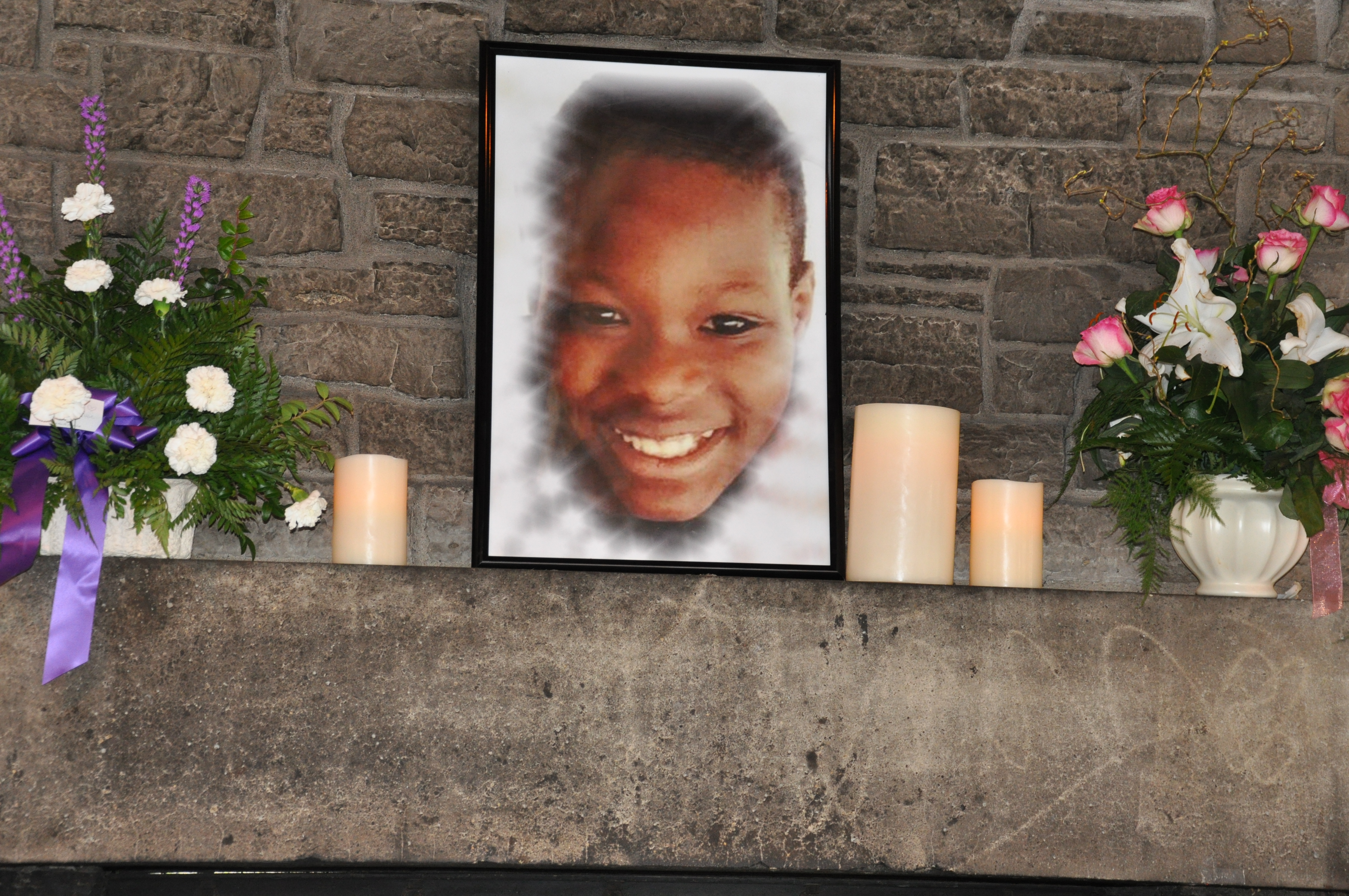 A picture of a child on the mantle.