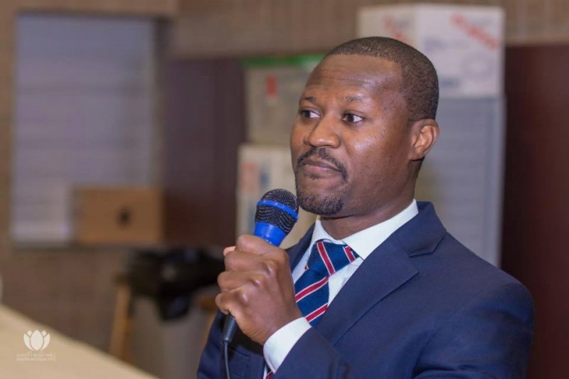 A man in a suit and tie holding a microphone.