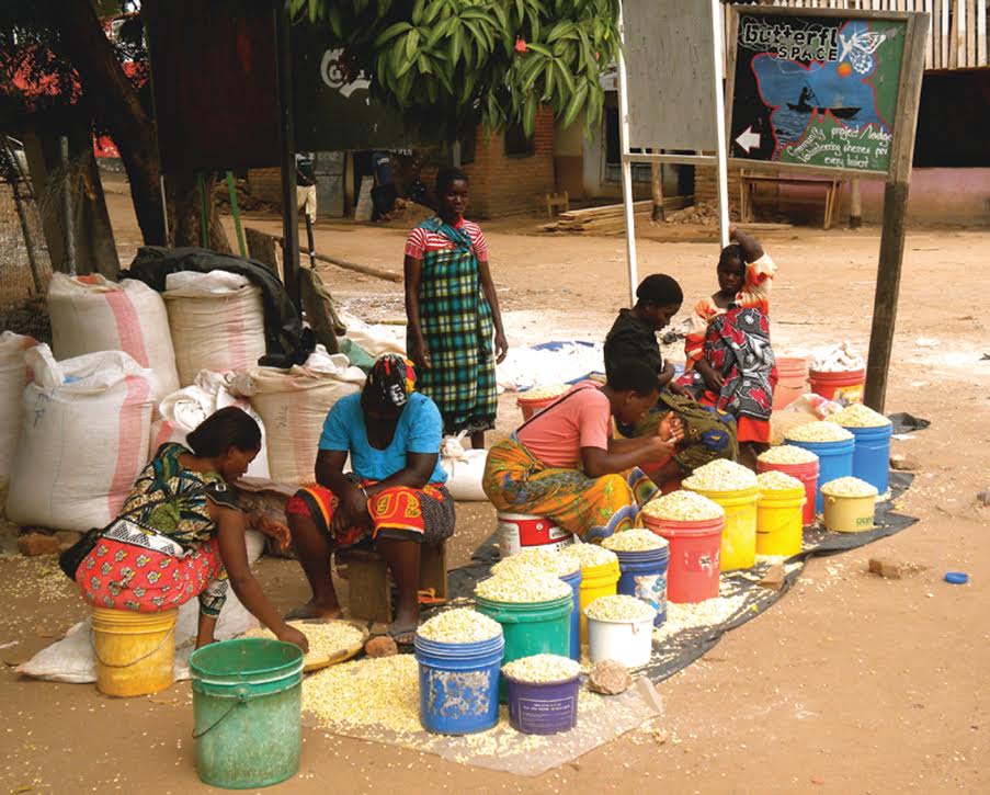 A group of people sitting around some buckets
