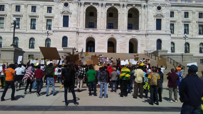 A group of people standing around in front of a building.
