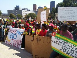 A group of people protesting in front of a building.