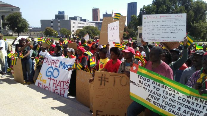 A group of people protesting in front of a building.