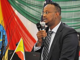 A man in suit and tie holding a microphone.