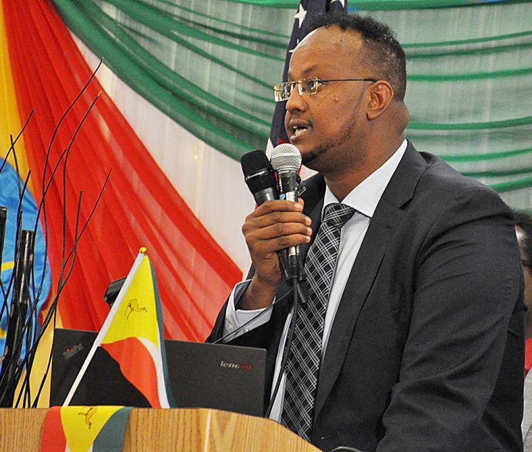 A man in suit and tie holding a microphone.