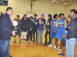 A group of people standing around in a gym.