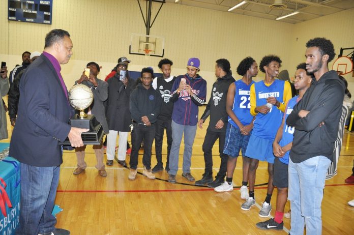 A group of people standing around in a gym.