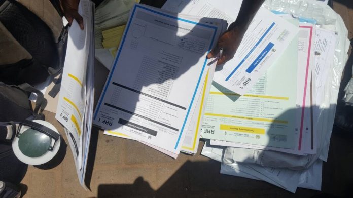 A person holding papers on top of some papers.