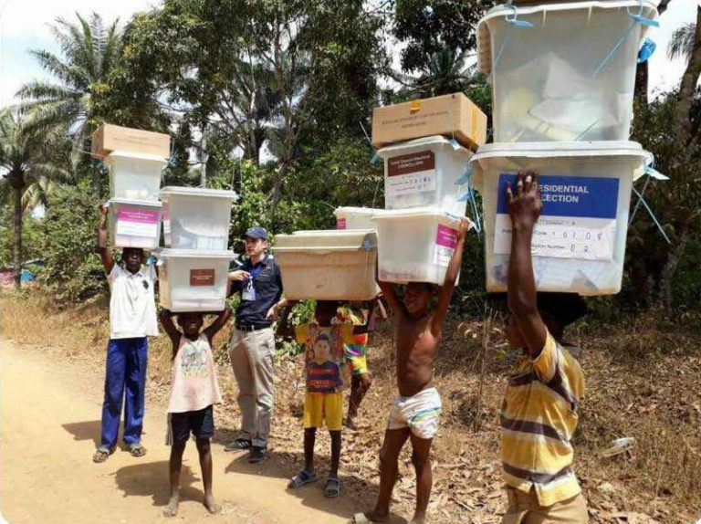A group of people carrying boxes on their heads.
