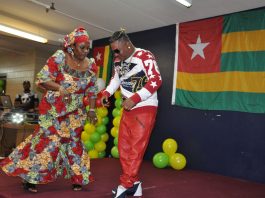 A man and woman dancing in front of balloons.