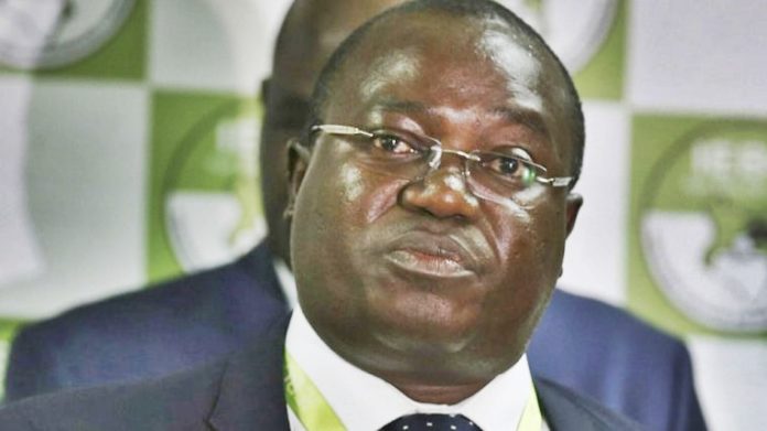 A man in glasses and suit is looking at the camera.