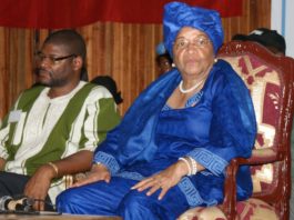 A woman in blue sitting on a chair next to another man.