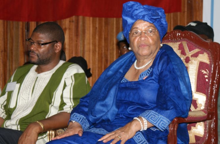 A woman in blue sitting on a chair next to another man.