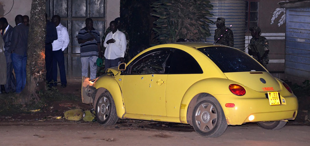 A yellow car that has been smashed by a man.