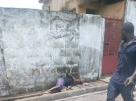 A man standing next to a person laying on the ground.