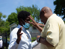 Two men wearing masks and one is touching the other 's face.