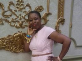 A woman in a pink dress posing for the camera.