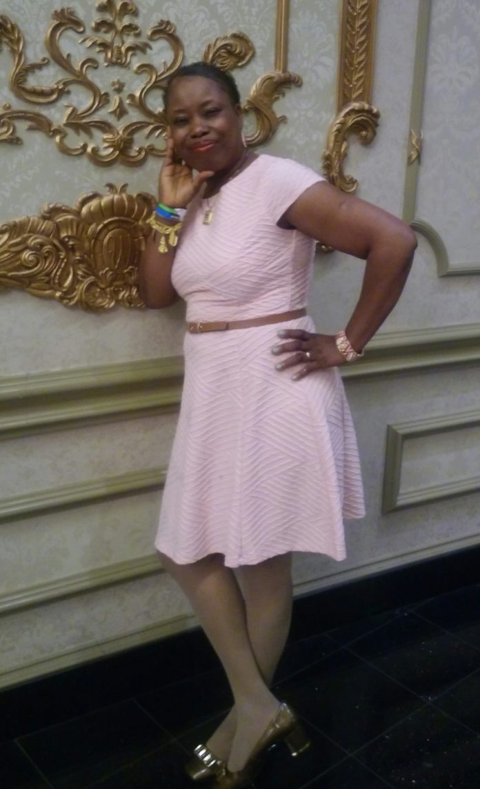 A woman in a pink dress posing for the camera.