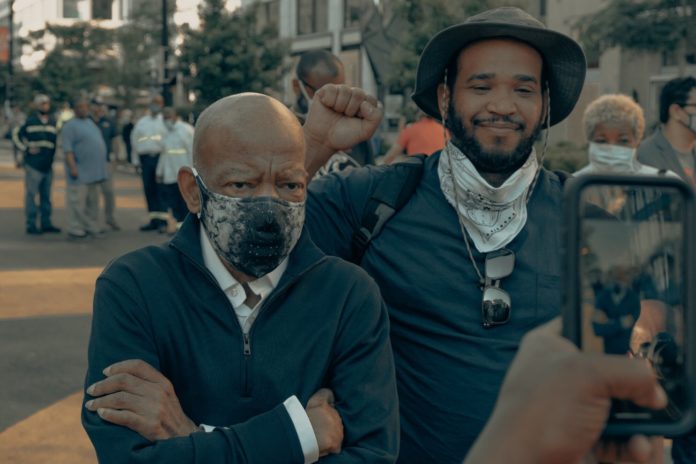 Two men in masks are standing together on the street.